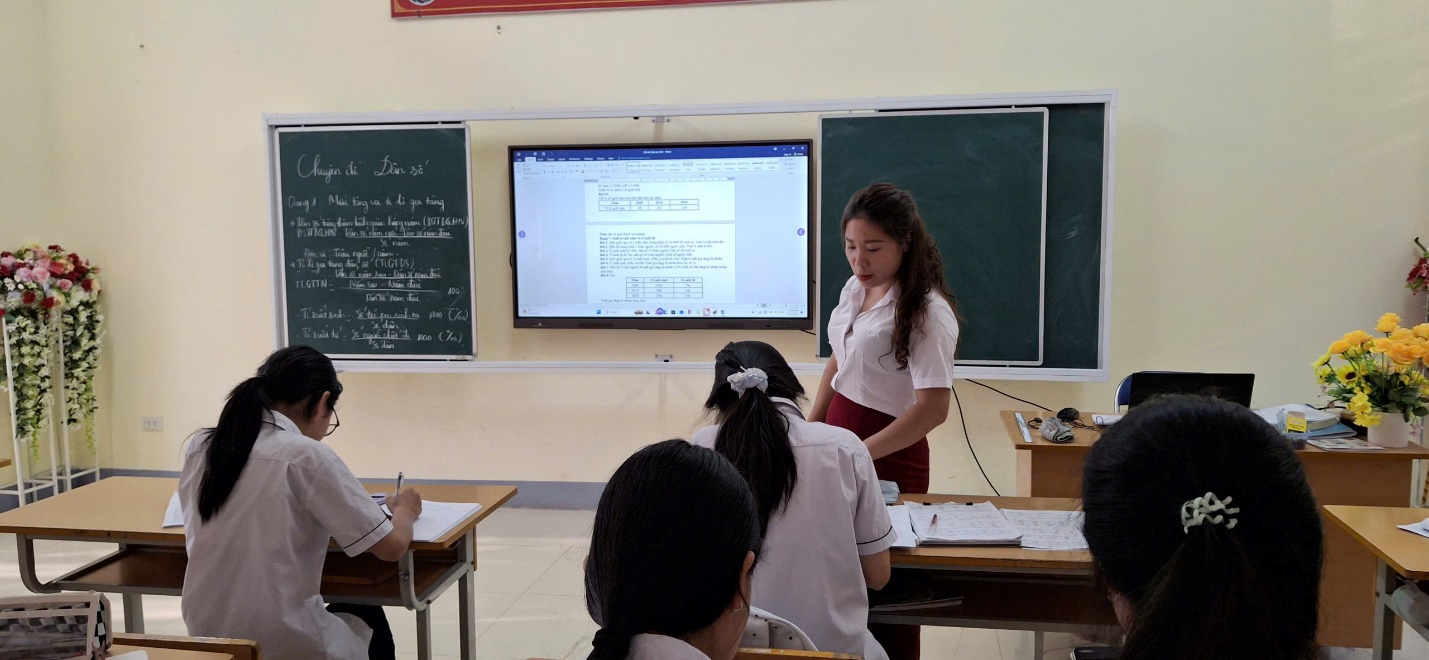 'A person standing in front of a screen
Description automatically generated'